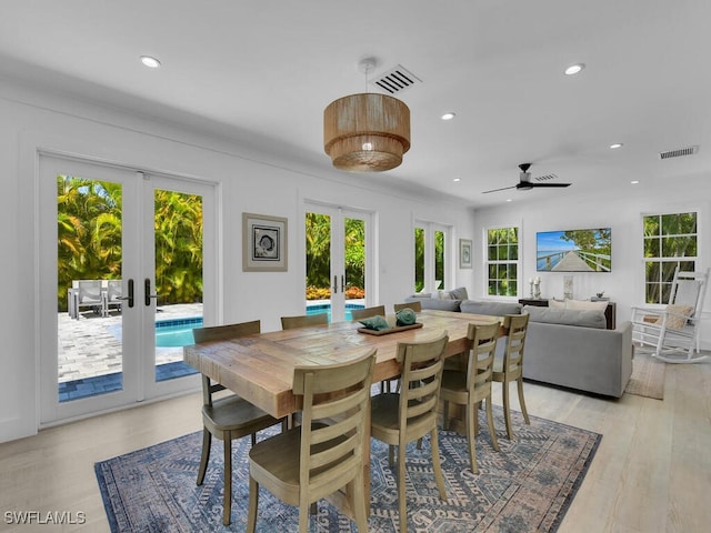 dining area with french doors, light hardwood / wood-style floors, and a wealth of natural light