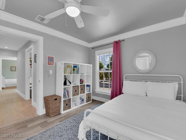 bedroom with crown molding, hardwood / wood-style floors, and ceiling fan