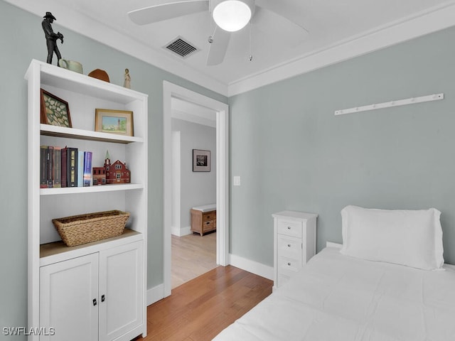 bedroom featuring crown molding, ceiling fan, and light hardwood / wood-style flooring