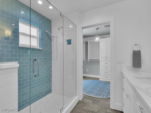 bathroom featuring hardwood / wood-style flooring, vanity, and a shower with shower door