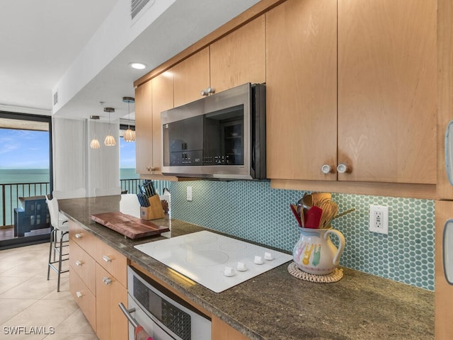 kitchen with a water view, decorative light fixtures, white electric cooktop, tasteful backsplash, and wall oven