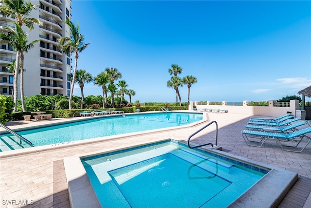 view of swimming pool with a community hot tub and a patio