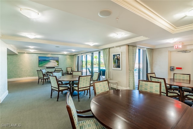 carpeted dining area with crown molding and a tray ceiling