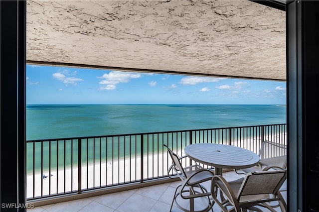 balcony with a water view and a view of the beach