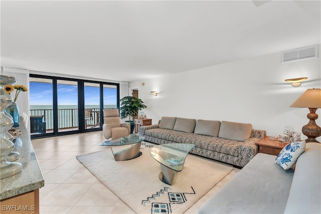 tiled living room with a water view and expansive windows