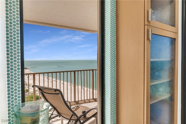 balcony featuring a water view and a beach view