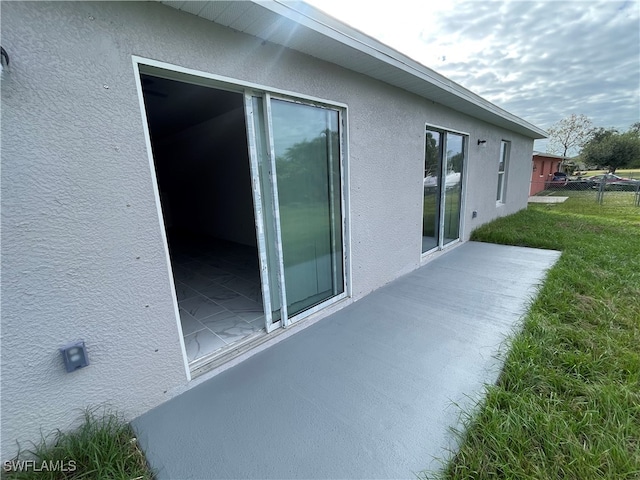 view of property exterior with a lawn and a patio