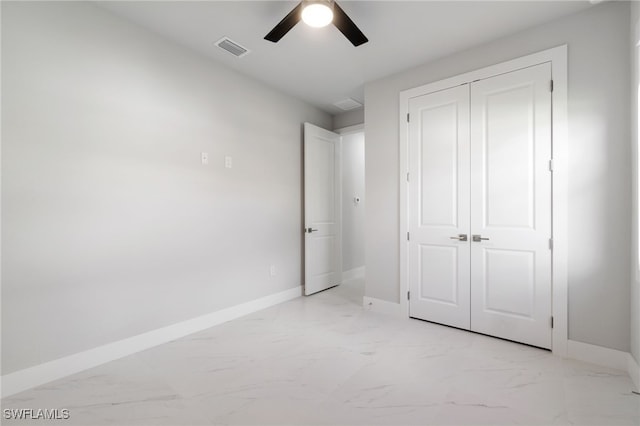 unfurnished bedroom featuring ceiling fan and a closet