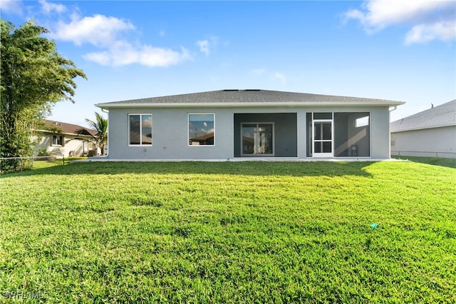 rear view of house with a sunroom and a yard