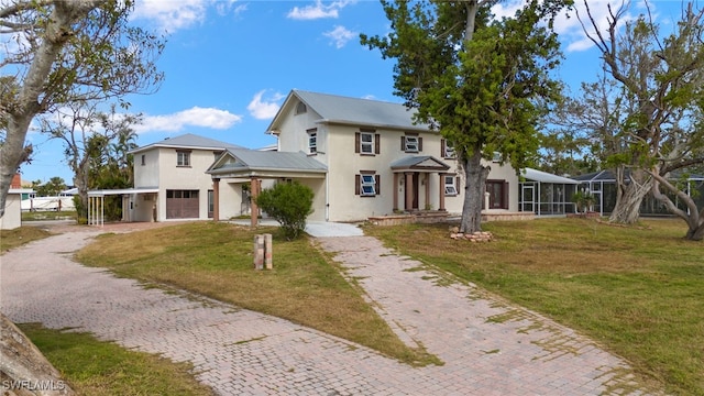 view of front of property with metal roof, a garage, decorative driveway, stucco siding, and a front yard