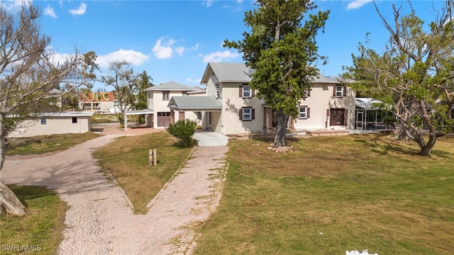 view of front of home featuring a residential view, decorative driveway, a front lawn, and stucco siding