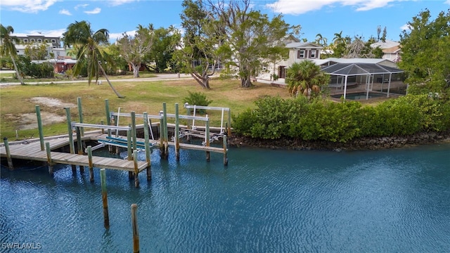 dock area featuring a lanai, a water view, a yard, and boat lift