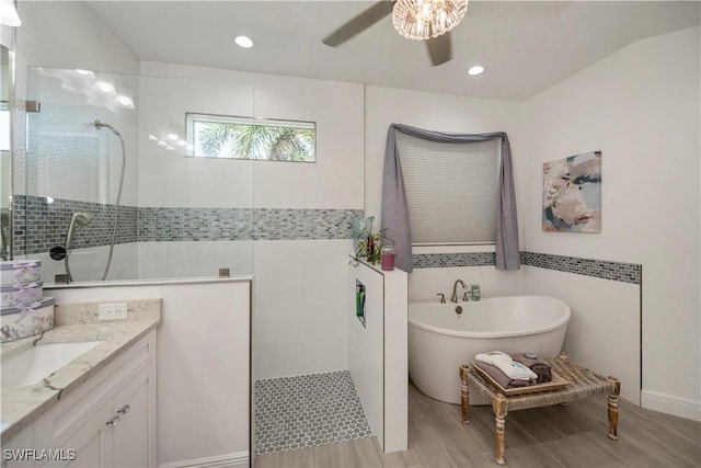 full bathroom with ceiling fan, vanity, a freestanding tub, a walk in shower, and recessed lighting