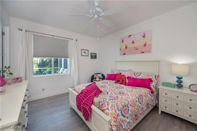 bedroom with ceiling fan, baseboards, and wood finished floors