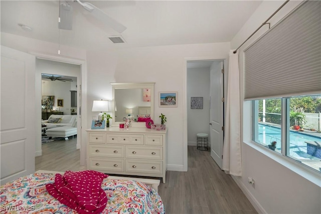 bedroom featuring visible vents, ceiling fan, baseboards, and wood finished floors