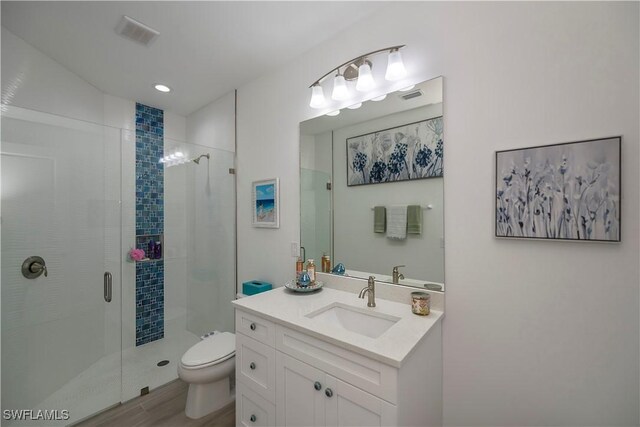 full bathroom with toilet, a shower stall, visible vents, and vanity