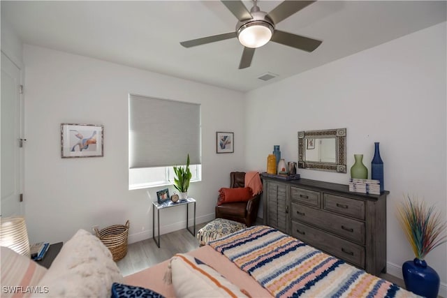 bedroom featuring baseboards, visible vents, ceiling fan, and wood finished floors