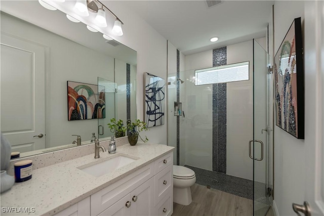 full bath featuring toilet, a stall shower, wood finished floors, and vanity