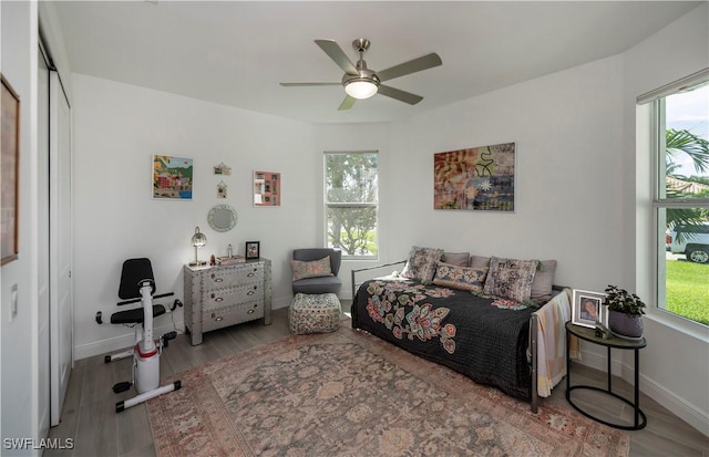 bedroom with a ceiling fan, baseboards, and wood finished floors