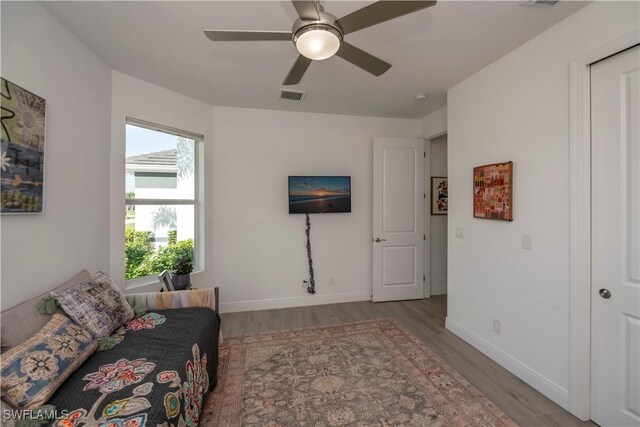 living area featuring visible vents, baseboards, and wood finished floors