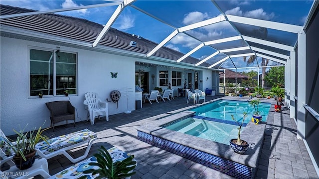 view of pool with glass enclosure and a pool with connected hot tub