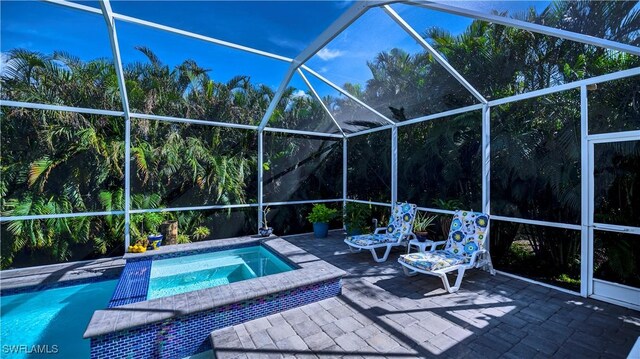 pool with an in ground hot tub and a lanai