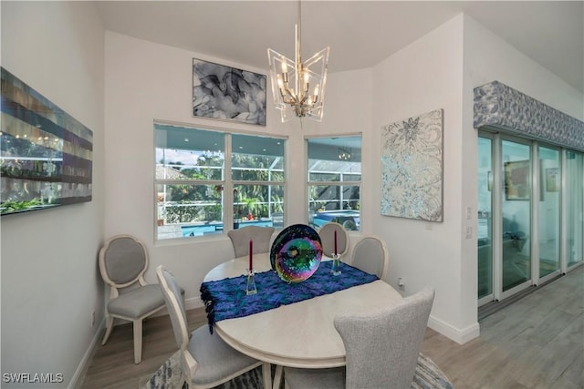 dining space featuring plenty of natural light, wood finished floors, baseboards, and a chandelier