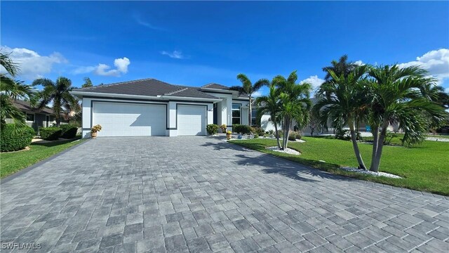 view of front of home with a garage and a front lawn