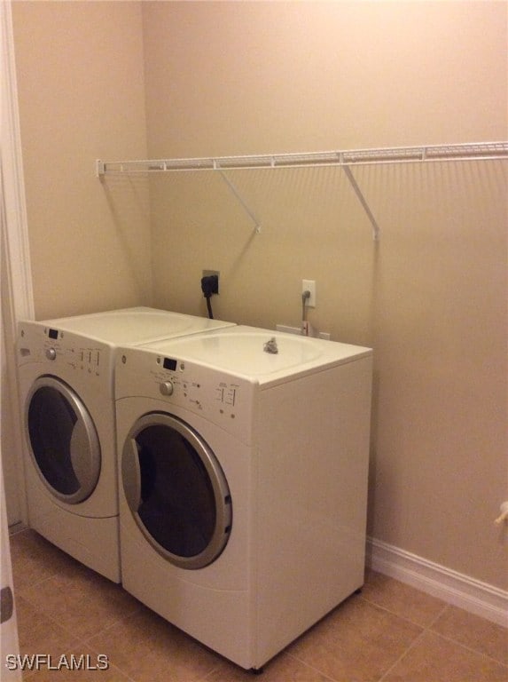 clothes washing area featuring light tile patterned floors and independent washer and dryer