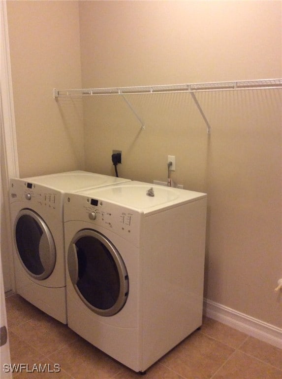 291 Saddlebrook Ln, Naples, FL 34110 - laundry room with washing machine and clothes dryer, light tile patterned flooring, and baseboards