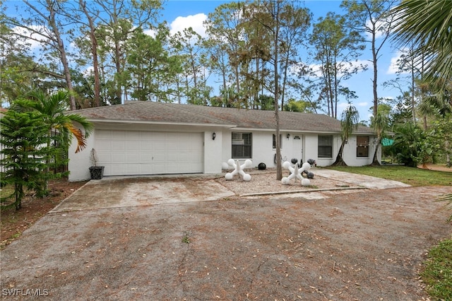 view of front facade featuring a garage, driveway, and stucco siding