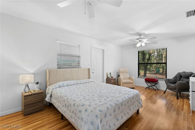 bedroom with baseboards, light wood-style floors, and a ceiling fan