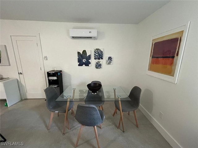 dining space featuring a wall mounted AC, concrete flooring, and baseboards
