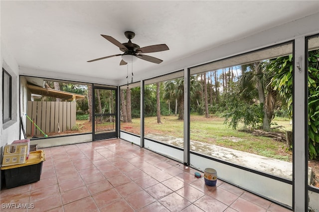 unfurnished sunroom featuring ceiling fan and plenty of natural light