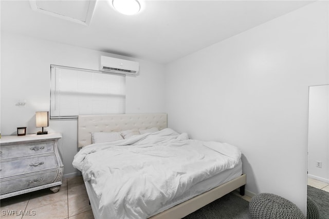 tiled bedroom with a wall mounted air conditioner, baseboards, and attic access