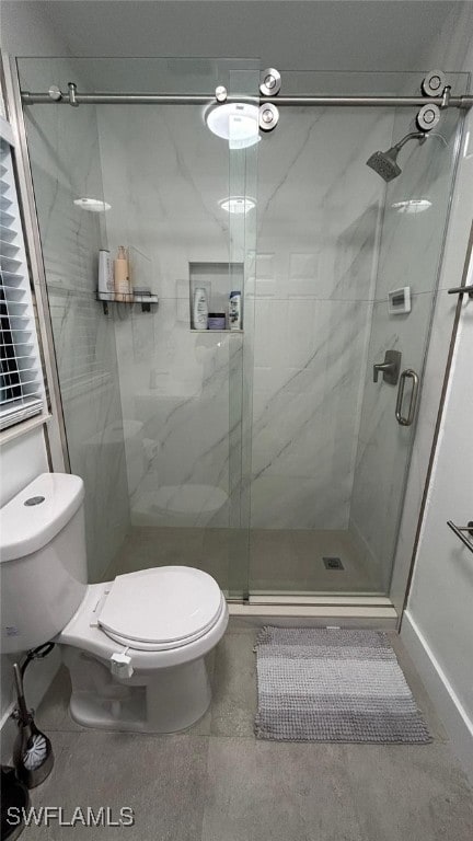 bathroom with toilet and a shower with door