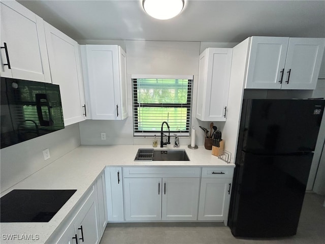 kitchen with white cabinetry, sink, black appliances, and light stone counters