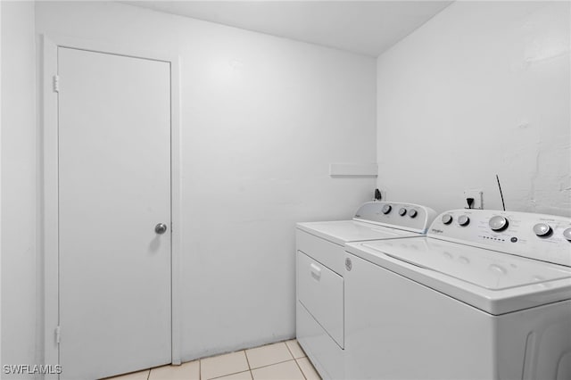 laundry room featuring separate washer and dryer and light tile patterned floors