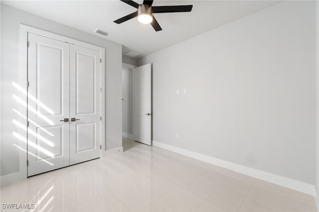 unfurnished bedroom featuring light tile patterned floors, a closet, and ceiling fan