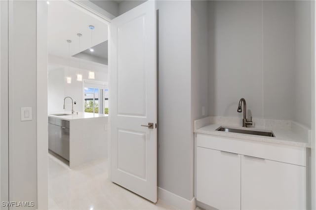 bar featuring white cabinets, light tile patterned flooring, and sink