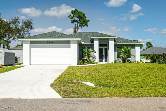 view of front of property featuring a front yard and a garage