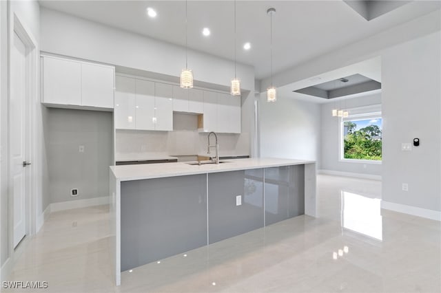 kitchen with white cabinetry, sink, backsplash, pendant lighting, and light tile patterned flooring