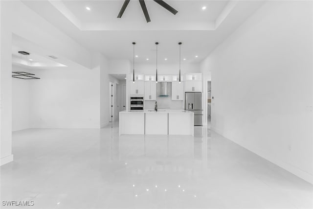 unfurnished living room with sink and a tray ceiling