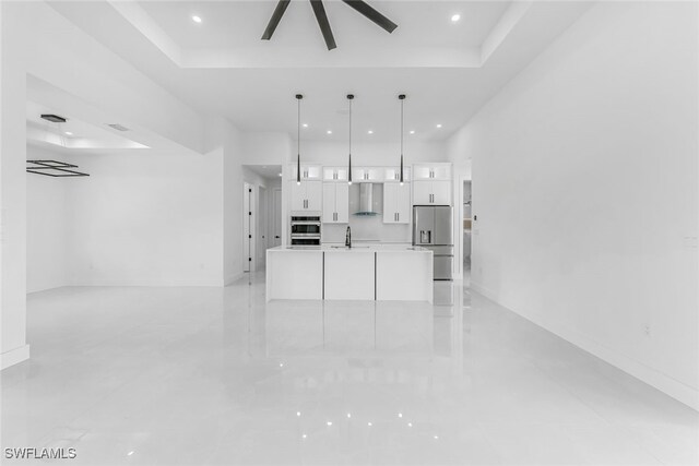 unfurnished living room featuring visible vents, a raised ceiling, a ceiling fan, a sink, and recessed lighting