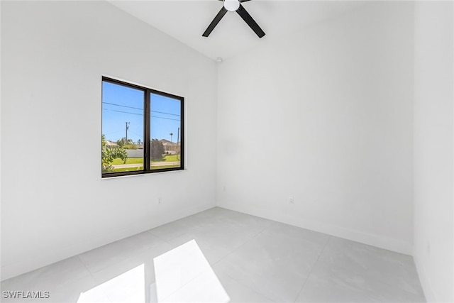 tiled empty room featuring ceiling fan