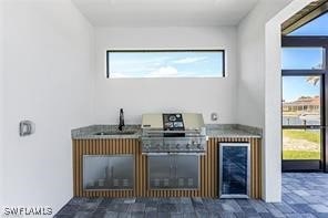 bar with wine cooler, plenty of natural light, and sink