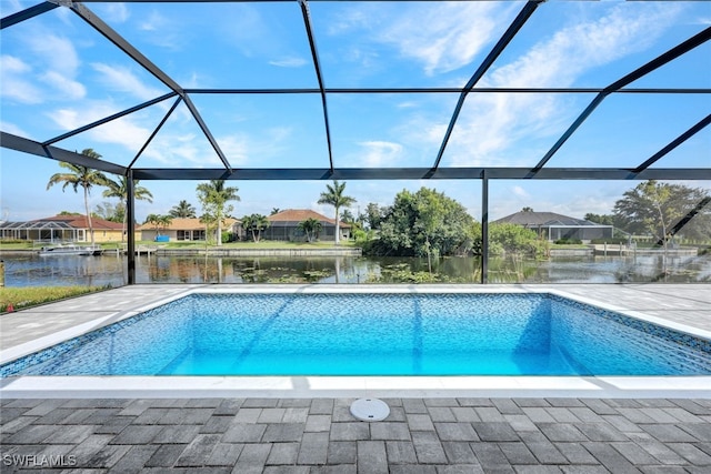 view of swimming pool featuring glass enclosure, a water view, and a patio