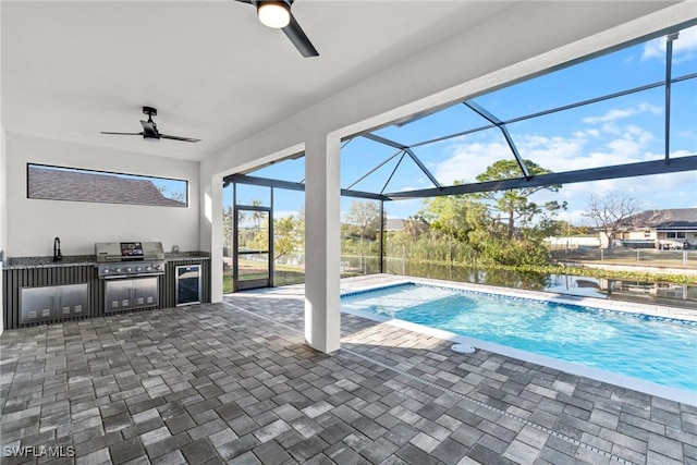 outdoor pool featuring exterior kitchen, a sink, a patio, and area for grilling