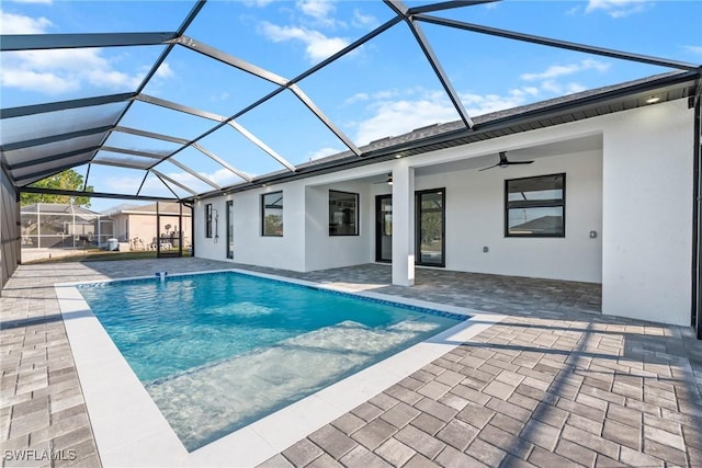 outdoor pool featuring a patio area, glass enclosure, and ceiling fan