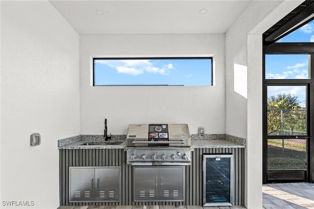 bar featuring a healthy amount of sunlight, beverage cooler, indoor bar, and a sink